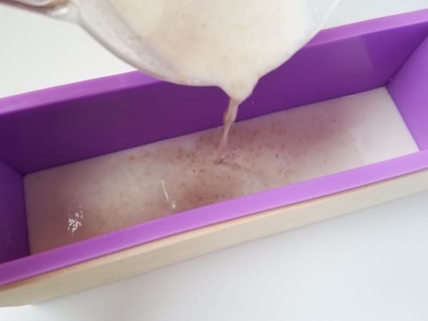 Pouring melted oatmeal lavender soap in a mold