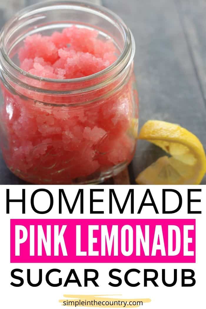 homemade pink lemonade sugar scrub in a mason jar with a slice of lemon beside it.